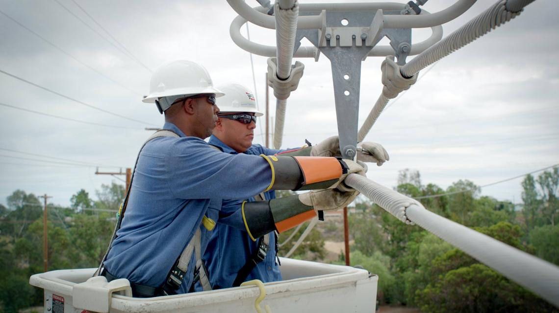 西班牙&E team members replace wooden poles with fire-resistant steel ones